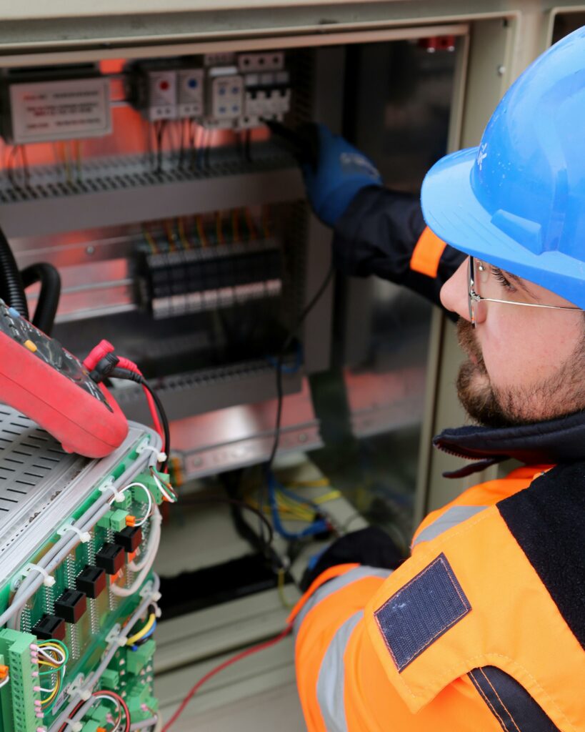 Électricien en train de travailler sur un tableau électrique